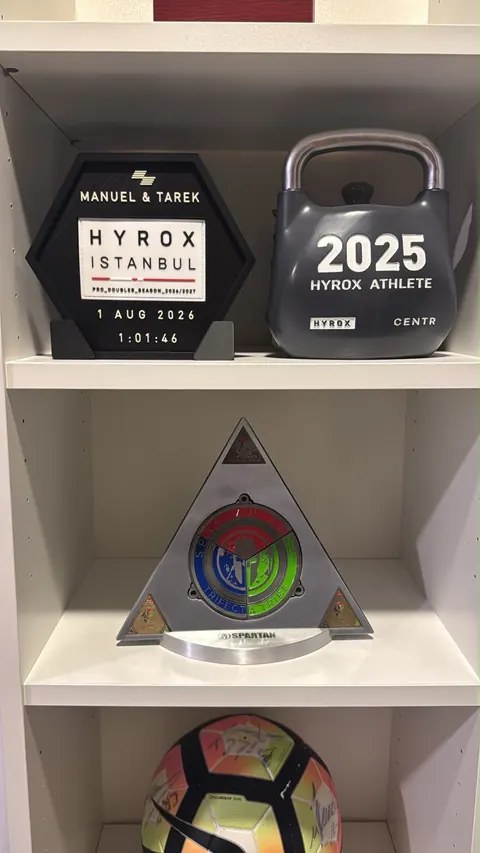 HYROX Istanbul — Shelf Display — Stand-mounted hex display alongside race trophies.