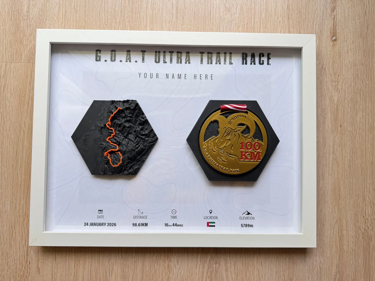 GOAT Ultra Trail Race — White Frame with Medal — White frame with hex relief and 100KM finisher medal.